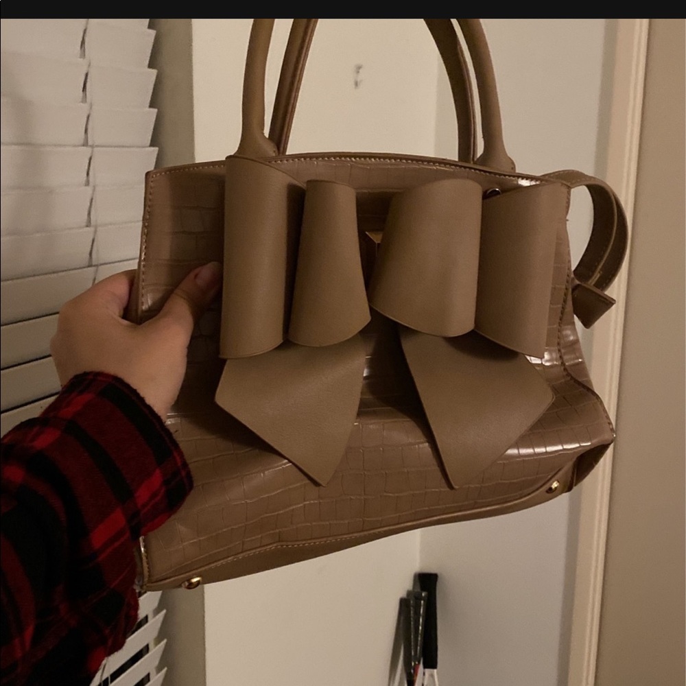 Beige bag bent up with fake alligator type style and big bow. Never been used